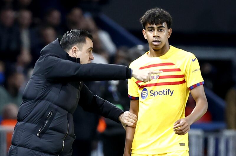 El entrenador del Barcelona Xavi Hernandez (I) dialoga con su jugador Lamine Yamal durante el partido de ida de cuartos de final de la UEFA Champions League en el Parque de los Príncipes de París. EFE/EPA/MOHAMMED BADRA