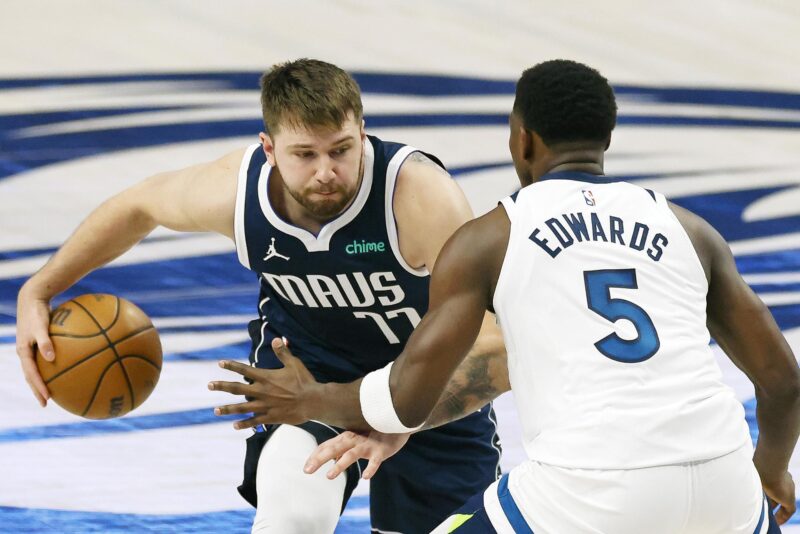 Luka Doncic (i) de los Dallas Mavericks transporta el balón con la marca de Anthony Edwards (d) de los Minnesota Timberwolves durante las finales del oeste de la NBA. EFE/EPA/ADAM DAVIS