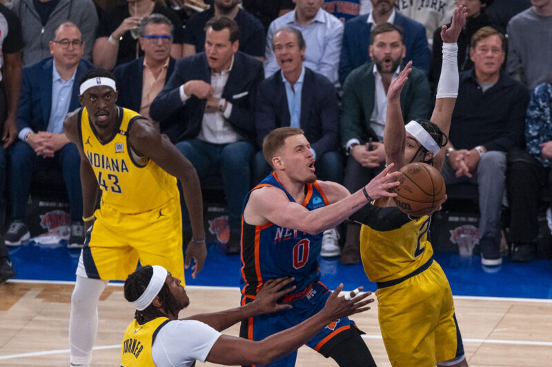 Donte DiVincenzo (c), escolta de los Knicks de Nueva York, fue registrado este martes, 14 de mayo, al atacar el aro que defiende Andrew Nembhard (d), de los Pacers de Indiana, durante el quinto partido de esta serie semifinal de la Conferencia Este de la NBA, en el coliseo Madison Square Garden de Nueva York (NY, EE.UU.) EFE/Ángel Colmenares