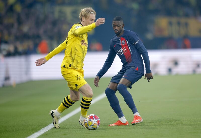 Ousmane Dembele (d), del PSG, defiende al jugador del Dortmund Julian Brandt durante el partido de vuelta de semifinales de la UEFA Champions League entre PSG y Dortmund en el Parque de los Príncipes de París. EFE/EPA/YOAN VALAT