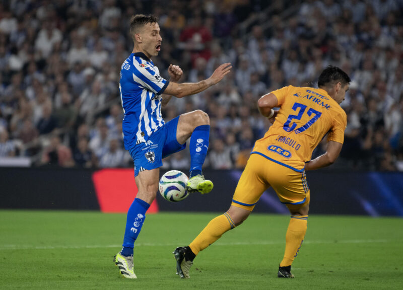 Sergio Canales (i) de Monterrey disputa el balón con Jesus Angulo de Tigres, este domingo durante el partido de vuelta de los cuartos de final del Torneo Clausura mexicano 2024. EFE/Miguel Sierra