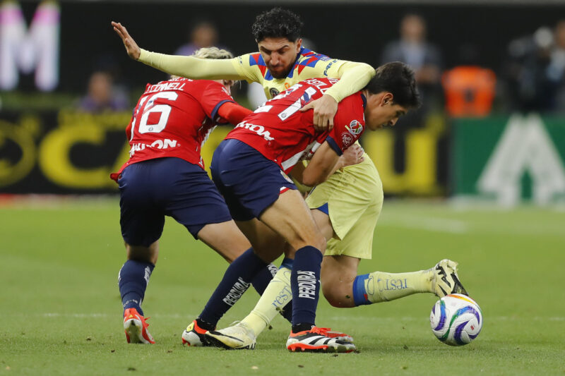 Cade Cowell (i) y José Castillo (d) del Guadalajara disputaN el balón con Diego Valdés de América este miércoles, durante un partido de las semifinales del torneo clausura 2024 de la Liga Mx, disputado en el Estadio Akron en la ciudad de Guadalajara (México). EFE/ Francisco Guasco