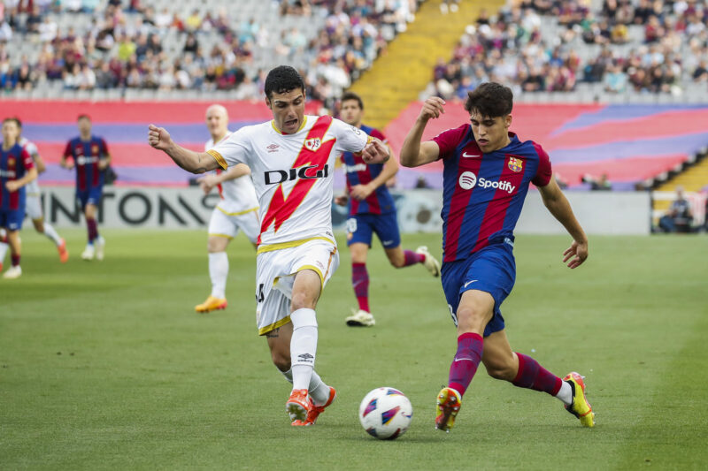 El defensa del FC Barcelona, Pau Cubarsi (d), con el balón ante el defensa francés del Rayo Vallecano, Florian Lejeune, durante el encuentro correspondiente a la jornada 37 de Primera División que FC Barcelona y Rayo Vallecano disputan hoy Domingo en el estadio Lluis Companys, en Barcelona. EFE / Marta Pérez.