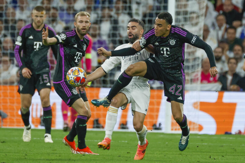El defensa del Real Madrid Dani Carvajal (2d) lucha con Jamal Musiala (d), del Bayern de Múnich, durante el partido de vuelta de las semifinales de la Liga de Campeones en el estadio Santiago Bernabéu, en Madrid. EFE/Juanjo Martín