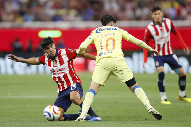 Erick Gutiérrez (i) del Guadalajara disputa el balón con Diego Valdés de América este miércoles, durante un partido de las semifinales del torneo clausura 2024 de la Liga Mx, disputado en el Estadio Akron en la ciudad de Guadalajara (México). EFE/ Francisco Guasco