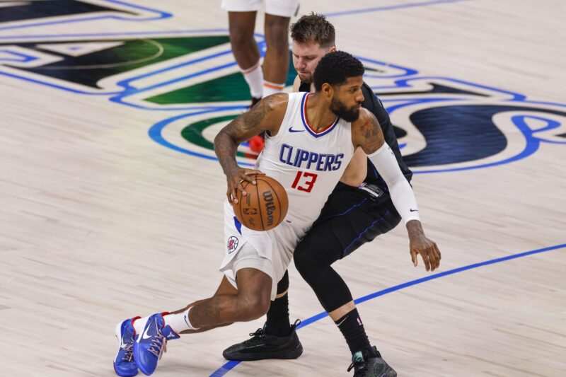 El jugador de los Angeles Clippers Paul George (i) pasa al de los Dallas Mavericks Luka Doncic (d) durante la segunda mitad del partido entre los Angeles Clippers y Dallas Mavericks en Dallas, Texas. EFE/EPA/ADAM DAVIS
