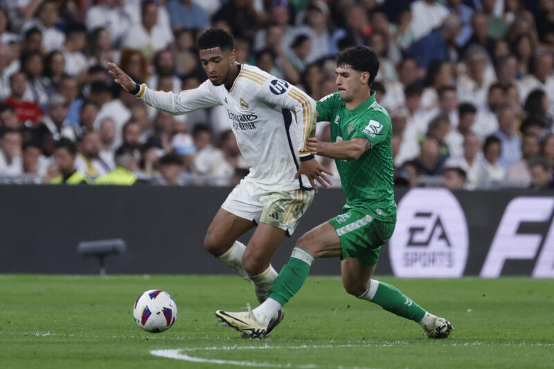 El centrocampista británico del Real Madrid Jude Bellingham (i) lucha con Johnny Cardoso, del Betis, durante el partido de la jornada 38 de LaLiga que Real Madrid y Real Betis disputan hoy sábado en el estadio Santiago Bernabéu, en Madrid. EFE/Javier Lizón