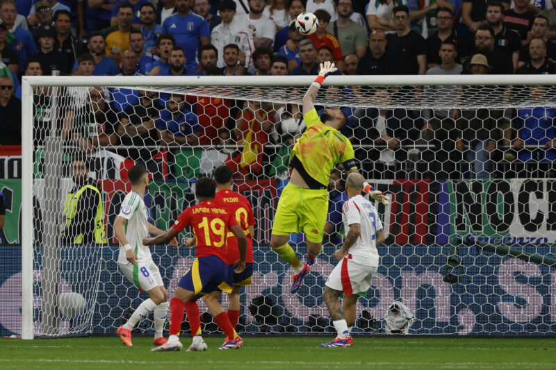 GELSENKIRCHEN (ALEMANIA), 20/06/2024.- El guardameta de la selección italiana, Gianluigi Donnarumma (2d), despeja un balón rematado por el centrocampista de España, Pedri, durante el encuentro correspondiente a la fase de grupos de la Eurocopa 2024 que España e Italia disputan hoy jueves en Gelsenkirchen (Alemania). EFE/J.J Guillén.