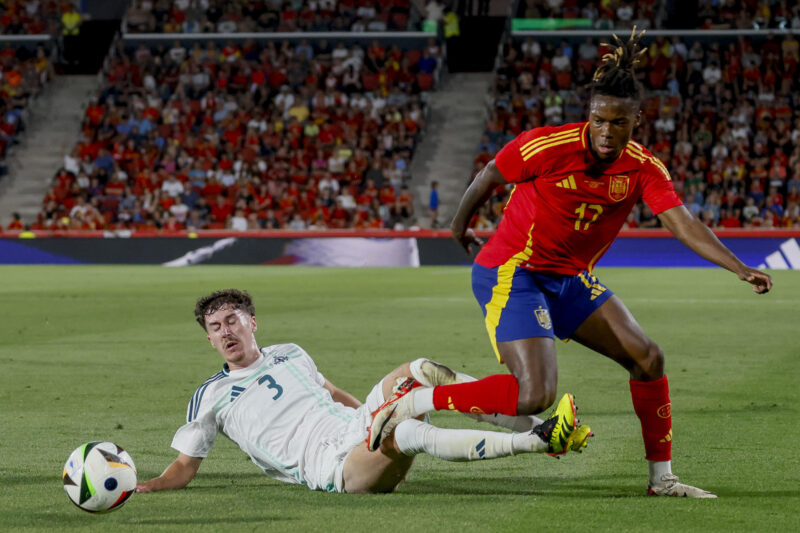 El delantero de la selección española Nico Williams (d) trata de escapar de Trai Hume, de Irlanda del Norte, durante el partido amistoso de fútbol disputado este sábado en el estadio de Son Moix. EFE/Cati Cladera