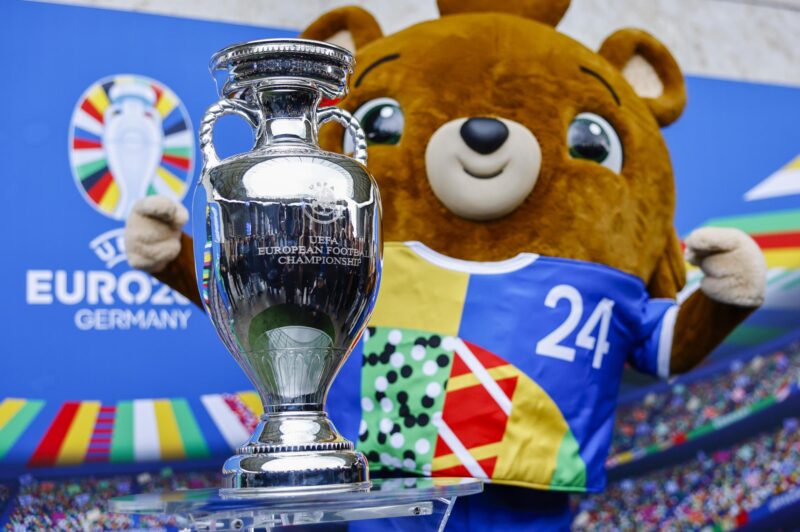 Albaert, la mascota de la Eurocopa 2024, posa junto al trofeo del torneo, en una foto de archivo. EFE/EPA/HANNIBAL HANSCHKE