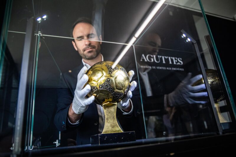 Francois Thierry, experto en deportes de la casa de subastas Aguttes, instala en la vitrina el trofeo del Balón de Oro de Diego Maradona, el trofeo otorgado al mejor jugador de la Copa Mundial de Fútbol de 1986, que finalmente no será subastado. EFE/EPA/CHRISTOPHE PETIT TESSON
