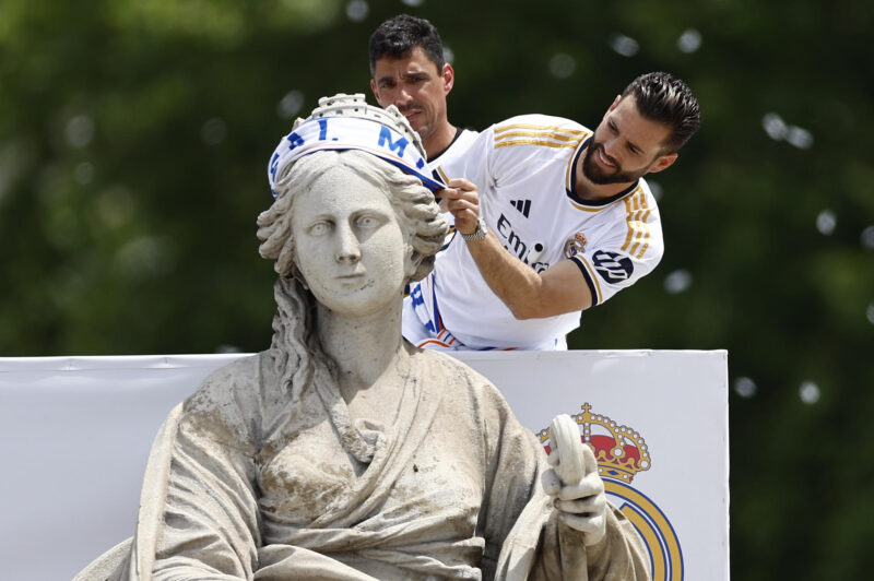 El capitán del Real Madrid, Nacho Fernández, coloca una bufanda a la diosa Cibeles durante la celebración con aficionados de la trigésimo sexta Liga, en la plaza de Cibeles. EFE/Rodrigo Jiménez