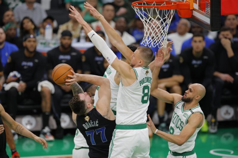 El jugador de los Boston Celtics Kristaps Porzingis (C) bloquea un tiro del guardia de los Dallas Mavericks Luka Doncic (i). EFE/EPA/CJ GUNTHER