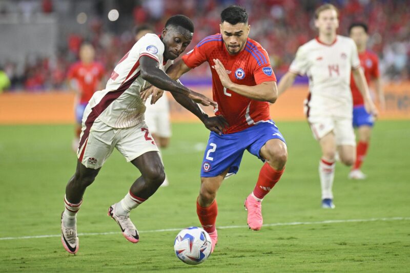 El delantero canadiense Richie Laryea (i) fue registrado este sábado, 29 de junio, al disputar un balón con el defensor chileno Gabriel Suazo (c), durante el partido de cierre del grupo A de la Copa América 2024, en el estadio Inter&Co de Orlando (Florida, EE.UU). EFE/Miguel Rodríguez
