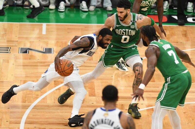 Kyrie Irving (i) avanza ante la marca de Jayson Tatum (C) y Jaylen Brown en el quinto juego de las Finales de la NBA en Boston. EFE/EPA/AMANDA SABGA