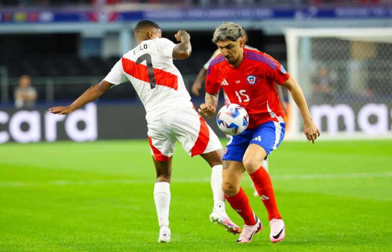 El centrocampista chileno Diego Valdés (d) fue registrado este viernes, 21 de junio, al intentar impedir el avance del atacante peruano Andy Polo (i), durante un partido de la primera jornada del grupo A de la Copa América, en el estadio AT&T de Arlington (Texas, EE.UU.). EFE/Kevin Jairaj