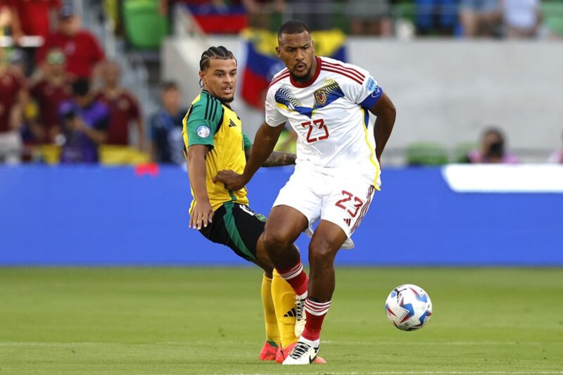 Joel Latibeaudiere (i), defensor de Jamaica, en acción contra el delantero venezolano José Salomon Rondon (d) en la Copa América 2024. EFE/EPA/ADAM DAVIS