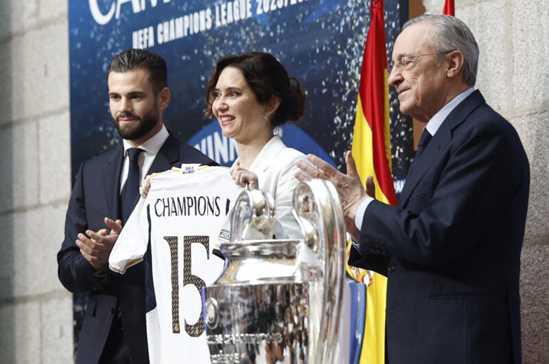 Nacho y una emotiva despedida: "Este club lo es todo para mi" El capitán y el presidente del Real Madrid, Nacho (i) y Florentino Pérez (d), respectivamente, entregan una camiseta del equipo a la presidenta de la Comunidad, Isabel Díaz Ayuso, en su visita a la Real Casa de Correos, sede de la Comunidad de Madrid, segunda parada del recorrido realizado este domingo por el equipo para celebrar su victoria en la final de la Liga de Campeones. EFE/Rodrigo Jiménez