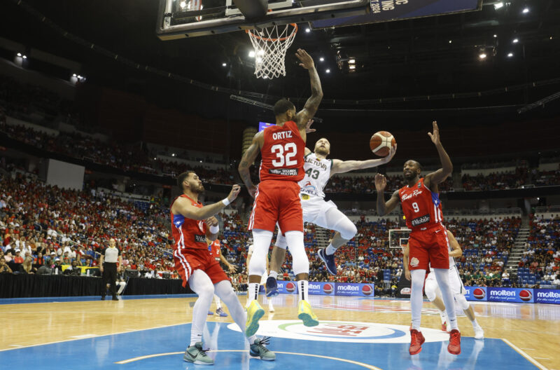 El lituano Lukas Lekavicius tira a canasta ante el marcaje del puertorriqueño Christopher Ortiz durante la final del Torneo Preolímpico de Baloncesto, este domingo en el Coliseo José Miguel Agrelot, de San Juan. EFE/ Thais Llorca