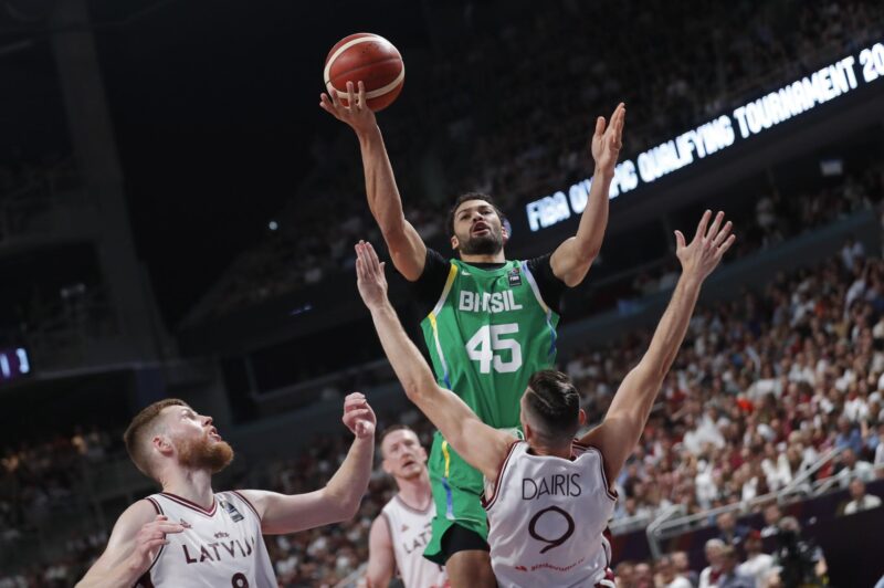 Brasil regresa a los Juegos Olímpicos después de 8 años Los jugadores letones Davis Bertans (I) y Dairis Bertans defienden Joao Cardoso de Brasil (c) durante el preolímpico de Riga en Letonia. EFE/EPA/TOMS KALNINS