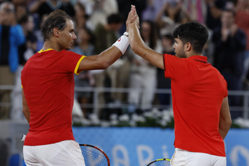 Los tenistas españoles Rafael Nadal (i) y Carlos Alcaraz celebran la victoria en el partido de dobles frente a los argentinos Máximo González y Andrés Molteni, correspondiente a la primera ronda de dobles masculino de tenis de los Juegos Olímpicos de París 2024 este sábado en la pista Phillipe Chatrier de París EFE/ Juanjo Martin