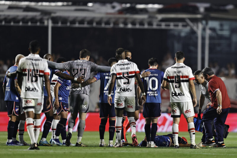 Los jugadores de Sao Paulo y Nacional rodean a Juan Izquierdo (abajo), tras su desmayo en el partido de vuelta de octavos de final de la Copa Libertadores entre Sao Paulo y Nacional en Brasil. EFE/ Isaac Fontana