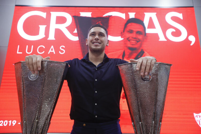 El jugador argentino Lucas Ocampos posa con dos trofeos conseguidos, durante su acto de despedida este martes. EFE/ José Manuel Vidal
