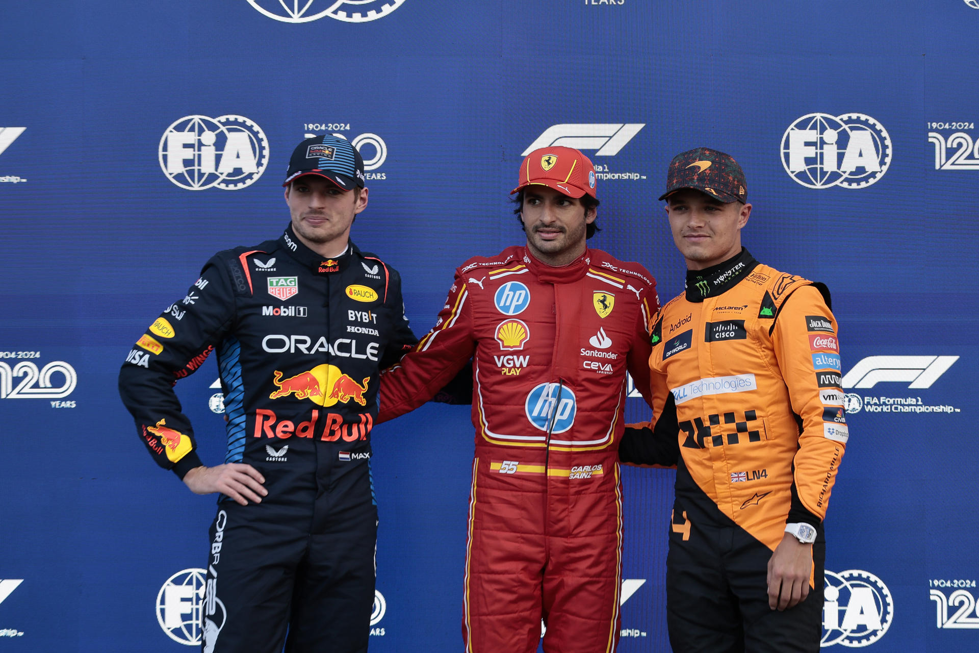 Los pilotos Max Verstappen (i), de Red Bull Racing; Carlos Sainz (c), de Ferrari, y Lando Norris, de McLaren, posan este sábado al final de la sesión de clasificación del GP de F1 en México. EFE/José Méndez